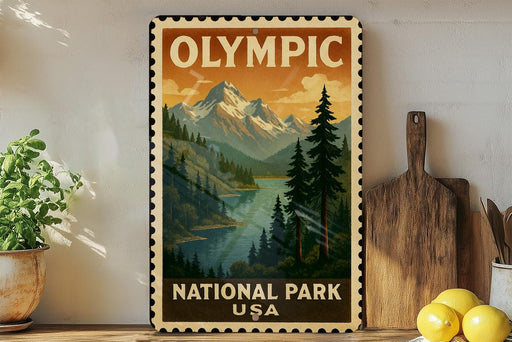 A vintage-style metal sign with a mountain landscape and pine trees, featuring the text "OLYMPIC NATIONAL PARK USA".