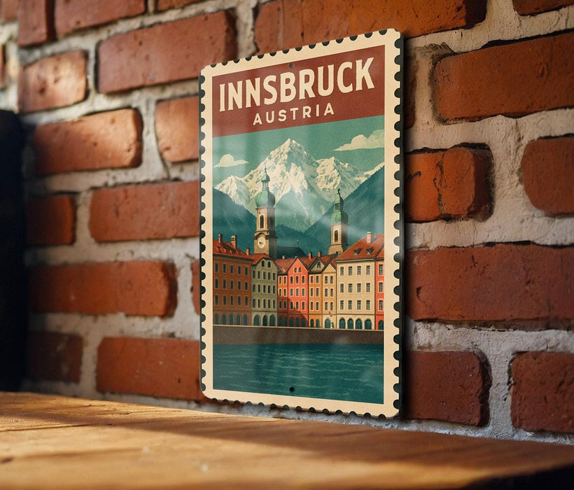A vintage-style poster of Innsbruck, Austria, featuring a mountain landscape and colorful buildings, is displayed on a brick wall.
