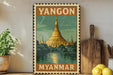 A vintage-style poster of the Shwedagon Pagoda, a famous Buddhist temple in Yangon, Myanmar, is displayed on a wall.