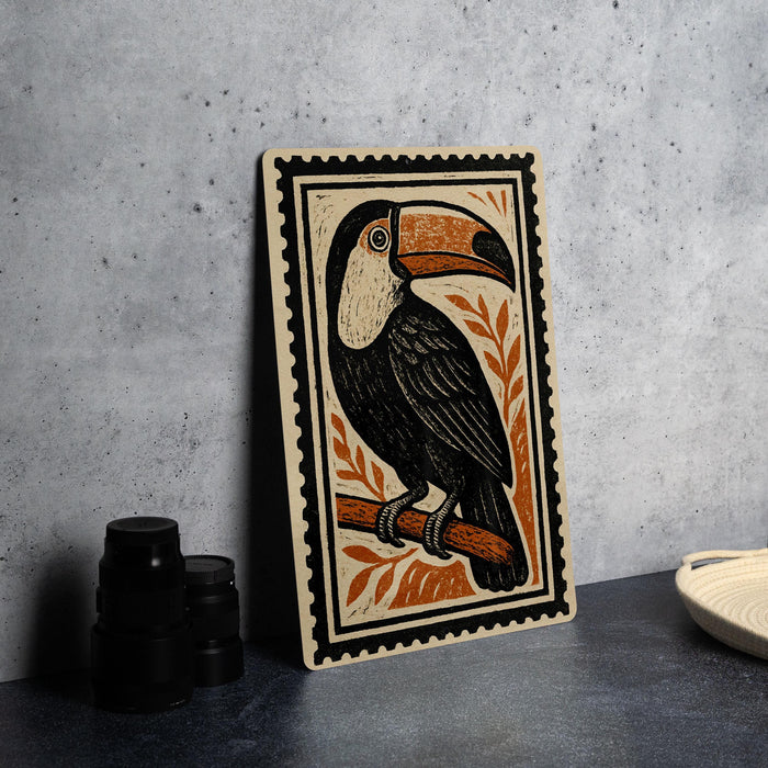 a wooden frame with a detailed illustration of a toucan perched on a branch, surrounded by orange leaves.
