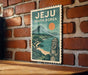 A vintage-style travel poster for Jeju, South Korea, featuring a mountain landscape and a stone statue, is displayed on a brick wall.