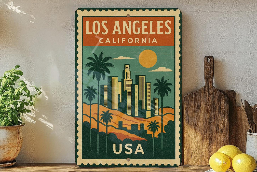 A vintage-style metal sign with a colorful illustration of Los Angeles, California, featuring palm trees, skyscrapers, and a sunset. The sign is framed with a border and displays the text "LOS ANGELES, CALIFORNIA USA".