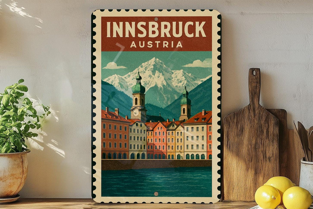 A framed poster of Innsbruck, Austria, featuring a scenic mountain landscape with colorful buildings and a river in the foreground.