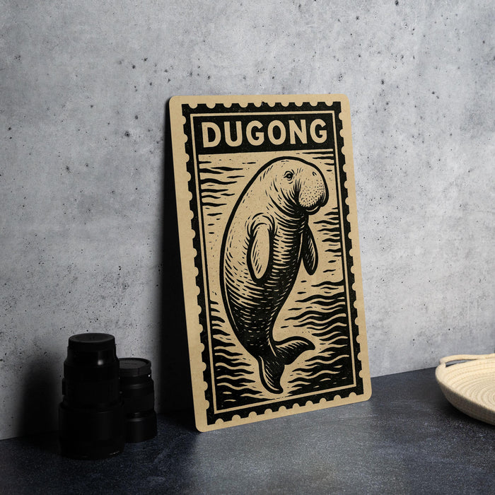 a wooden sign with a printed illustration of a dugout-like creature, possibly a dugout-like animal, and the word "DUGONG" written on it.