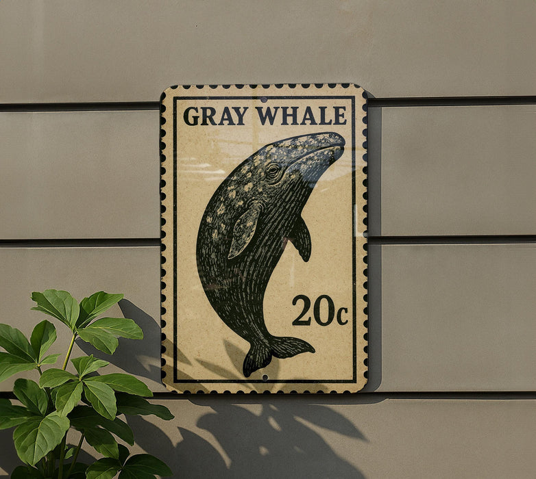 a gray whale on a postage stamp-like sign, mounted on a wall.