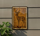 a decorative metal plaque with an illustration of a deer or antelope on it, mounted on a wall.