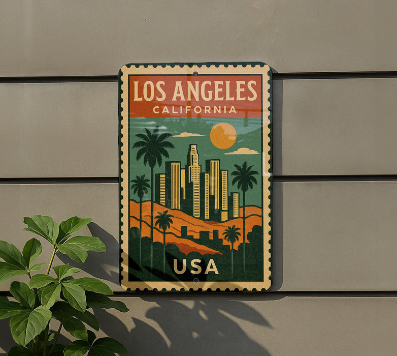 A vintage-style metal sign with a colorful illustration of Los Angeles, California, featuring palm trees, skyscrapers, and a sunset.