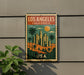 A vintage-style metal sign with a colorful illustration of Los Angeles, California, featuring palm trees, skyscrapers, and a sunset.