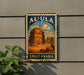 a vintage-style poster of the Al-Ula Mosque in Saudi Arabia, which is mounted on a wall.