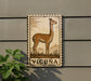 a decorative metal plaque with a depiction of a llama, mounted on a wall.