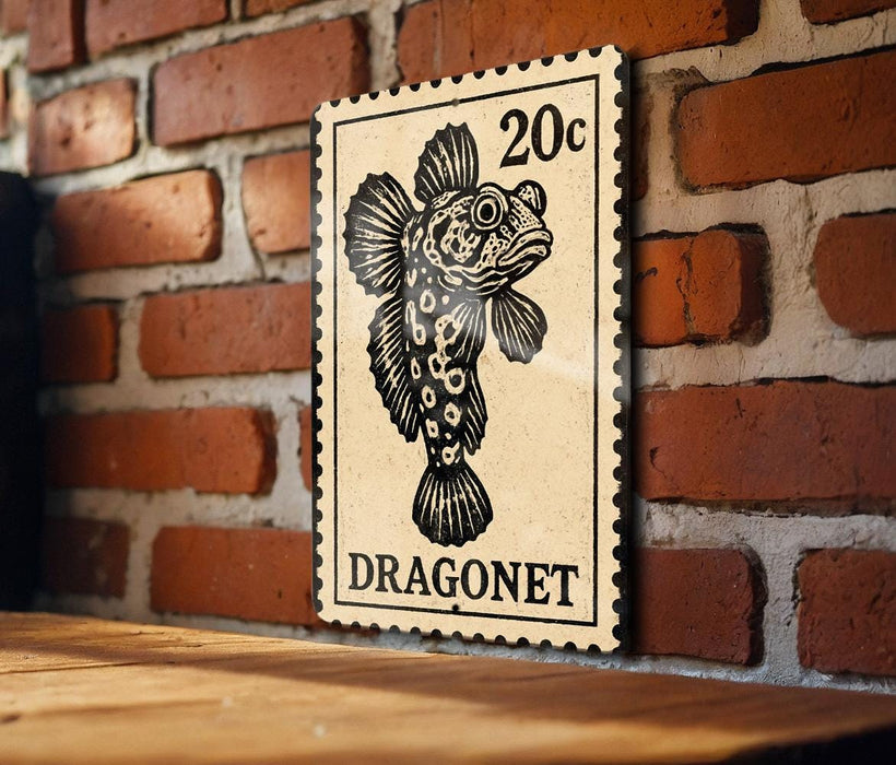 A 20c postage stamp featuring a dragon fish is displayed on a wooden surface against a brick wall.
