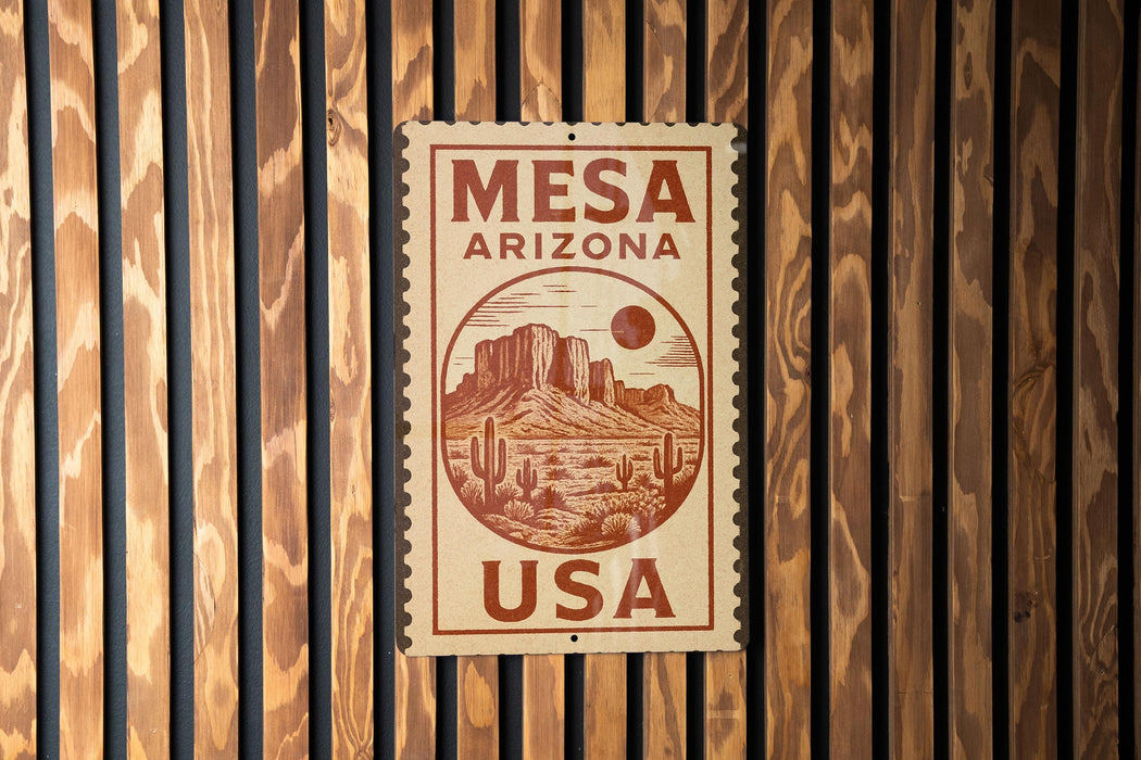 A wooden sign with the text "MESA ARIZONA USA" and an illustration of a desert landscape with mountains and cacti.