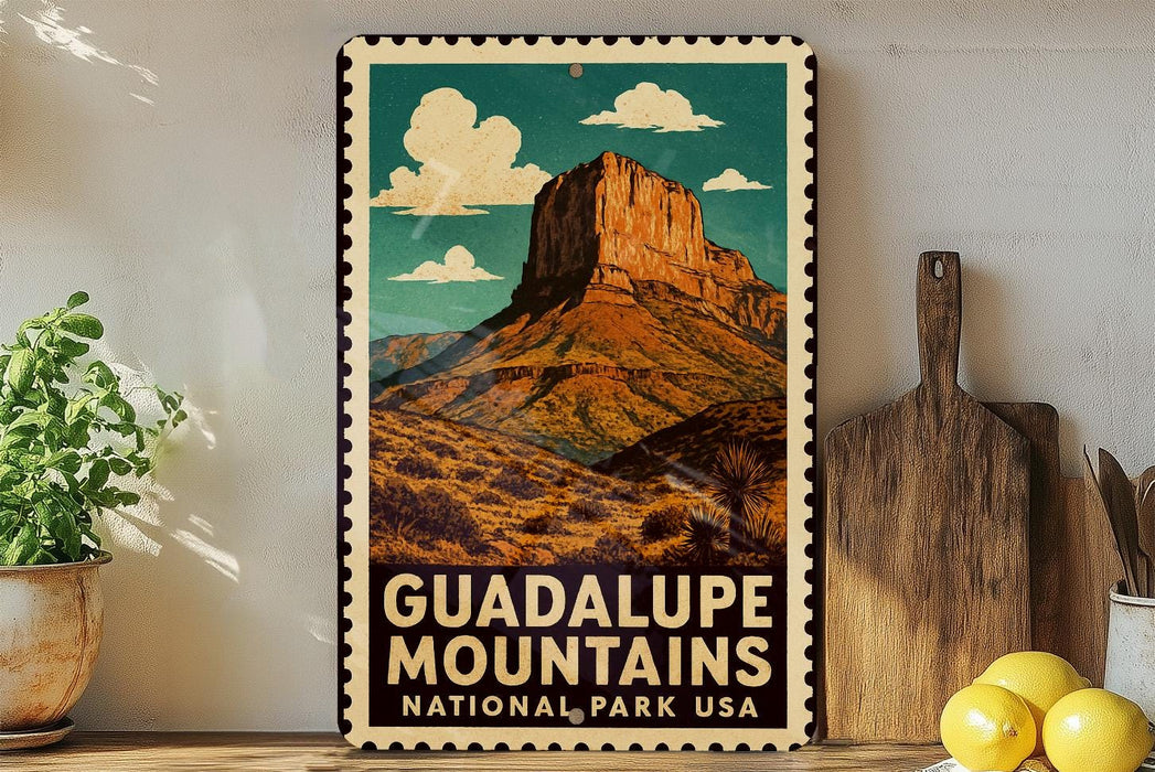 A vintage-style metal sign with a mountain landscape and clouds, featuring the text "GUADALUPE MOUNTAINS NATIONAL PARK USA".