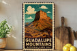 A vintage-style metal sign with a mountain landscape and clouds, featuring the text "GUADALUPE MOUNTAINS NATIONAL PARK USA".