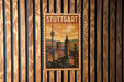 A vintage-style postage stamp depicting Stuttgart, Germany, with a cityscape and a tower in the background.