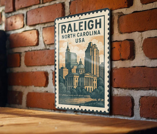 A metal sign with the text "RALEIGH NORTH CAROLINA USA" and an illustration of a city skyline, mounted on a brick wall.