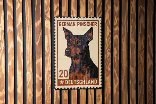 A German Pinscher dog is depicted on a German postage stamp, which is affixed to a wooden wall.