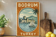 a vintage-style sign for Bodrum, Turkey, with a sailboat and a castle in the background.