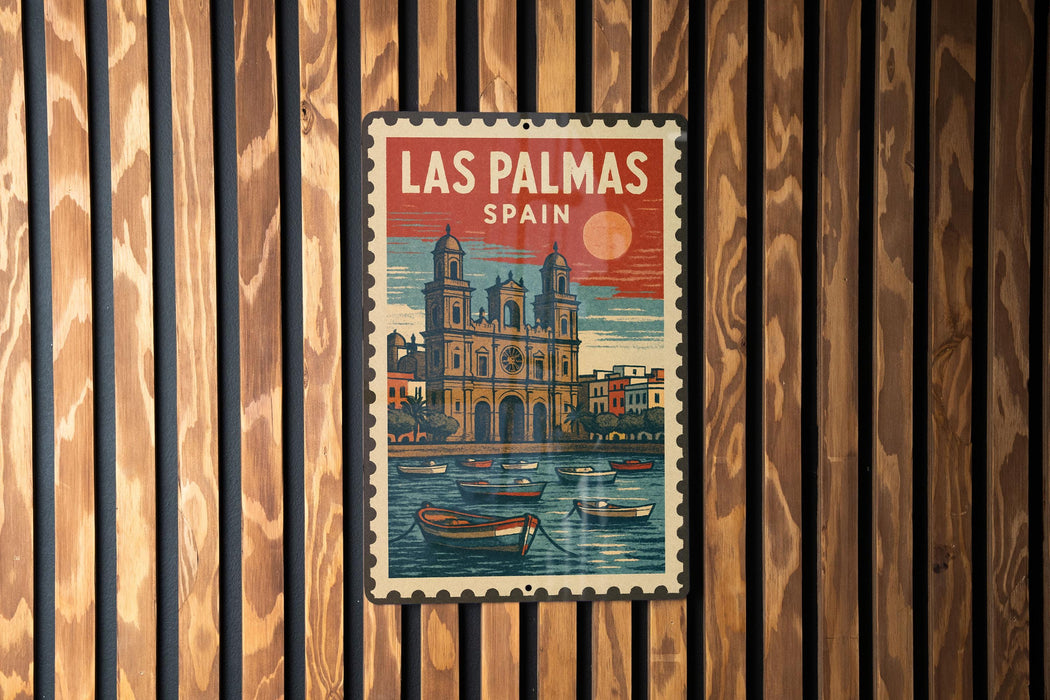A vintage-style metal sign with the text "LAS PALMAS SPAIN" and an illustration of a cityscape with a church, boats, and a sunset.