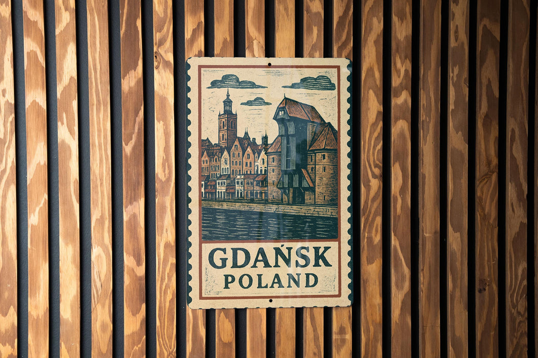 A vintage-style sign with a drawing of a cityscape and the text "Gdansk Poland" is displayed on a wooden wall.
