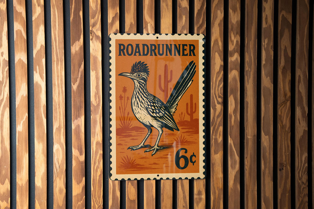 A vintage-style metal sign featuring a Roadrunner bird, mounted on a wooden wall.