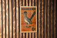 A vintage-style metal sign featuring a Roadrunner bird, mounted on a wooden wall.