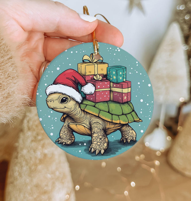 a hand holding a christmas ornament with a turtle on it