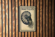 a nautilus shell on a wooden wall.