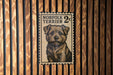 A postage stamp featuring a portrait of a small, shaggy dog with a brown and black color scheme.