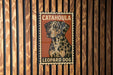 A poster of a leopard dog is displayed on a wooden wall.