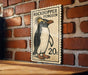 A vintage-style stamp featuring a penguin on a brick wall.