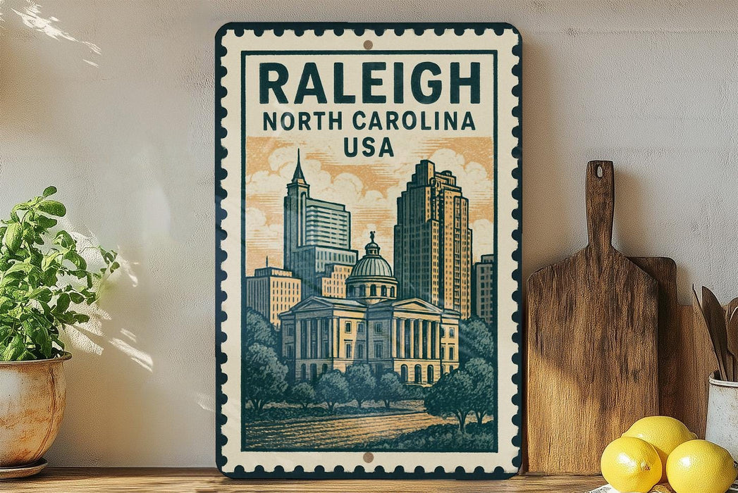 A framed poster of the Raleigh, North Carolina skyline, featuring a cityscape with tall buildings and a dome, is displayed on a shelf next to a wooden cutting board and some lemons.