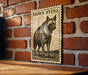 a wooden frame with a black and white illustration of a hyena on it, mounted on a brick wall.
