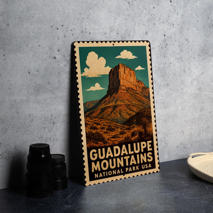 A metal sign with a vintage-style illustration of the Grand Canyon, featuring a mountain and a cloudy sky.