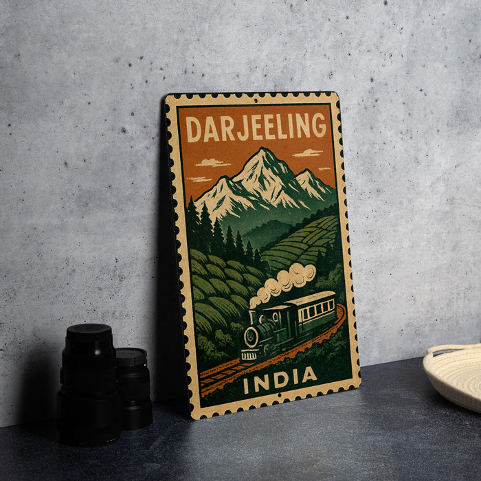 A vintage-style metal sign with a train and mountains in the background, depicting the scenic Darjeeling region in India.