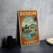 A vintage-style sign for Bodrum, Turkey, featuring a castle, palm trees, and a sailboat, is displayed on a table.