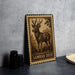 A wooden frame with a detailed engraved image of a Sambar deer, which is a type of deer native to the Indian subcontinent. The frame is placed on a gray surface, and there are some black objects, such as a stack of black camera lenses, to the left of the frame.