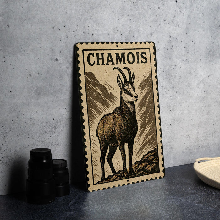 a metal stamp with a chamois illustration on it, placed on a table next to some black camera lenses.
