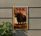 a 20-cent postage stamp with an illustration of a yak on it, mounted on a wall.