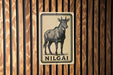 a sign with a black and white illustration of a goat, mounted on a wooden wall.
