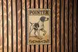 A metal sign with the word "POINTER" on it is displayed on a wooden wall.