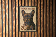 A French Bulldog stamp is affixed to a wooden wall.