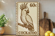 A wooden shelf displaying a stamp-like artwork of a cockatoo, a type of parrot, along with a wooden cutting board and some lemons.