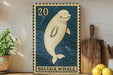 A framed image of a beluga whale, a type of whale, is displayed on a shelf next to a wooden cutting board and some lemons.