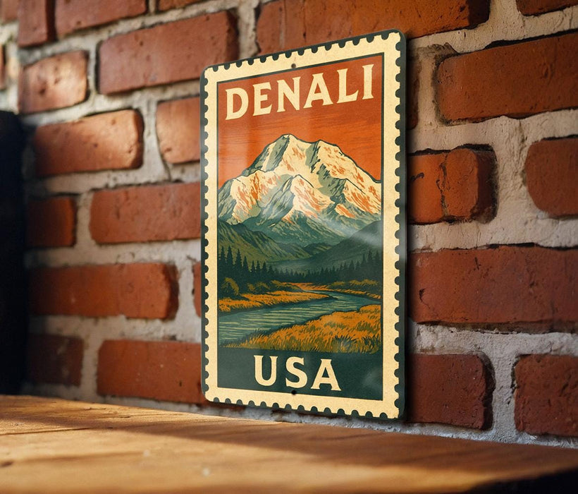 A vintage-style metal sign with the text "DENALI USA" displayed on a brick wall.