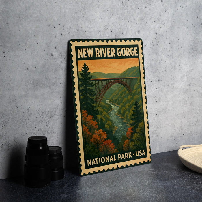 A metal sign with a scenic illustration of the New River Gorge National Park in the United States, featuring a bridge and lush greenery.