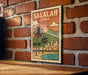 A vintage-style postage stamp depicting a coastal city scene with palm trees and a mountain in the background, hanging on a brick wall.