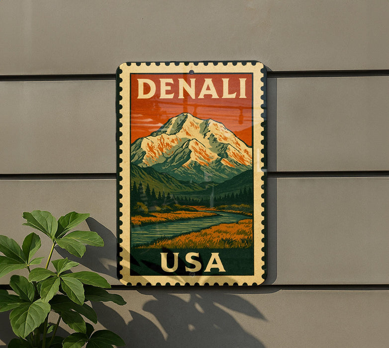 A vintage-style metal sign with a mountain landscape and a river, mounted on a wall.