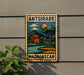 a vintage-style stamp or sign with a colorful illustration of a rural landscape, including a house, trees, and a body of water, mounted on a wall.