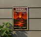A vintage-style metal sign with the text "HAWAII VOLCANOES" and "NATIONAL PARK USA" displayed on a wall, featuring an illustration of a volcano with lava flowing down its sides.